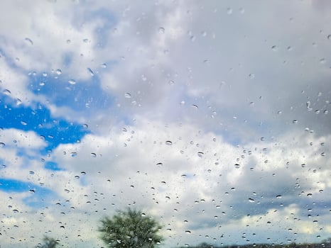 View from wet car window on rainy spring clouds photo