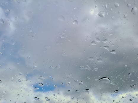 View from wet car window on rainy spring clouds photo
