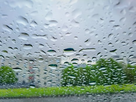 View from wet car window on rainy spring clouds photo