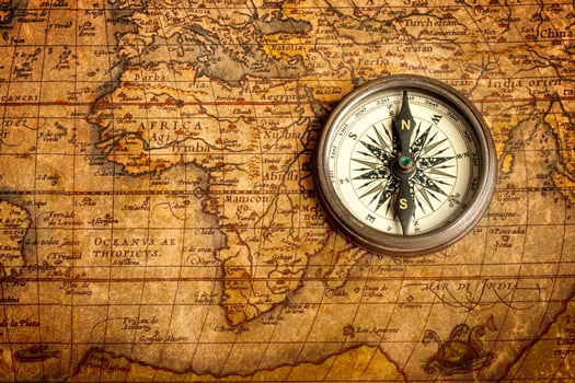 Old vintage compass on ancient map photo