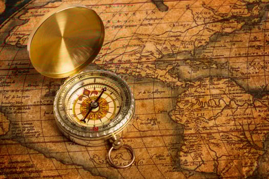 Old vintage golden compass on ancient map photo