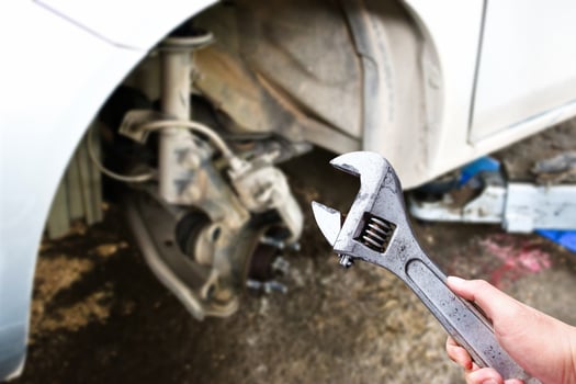 An adjustable spanner or adjustable wrench in the hand of an auto mechanic in the vehicle maintenance shop , Car maintenance service concept photo
