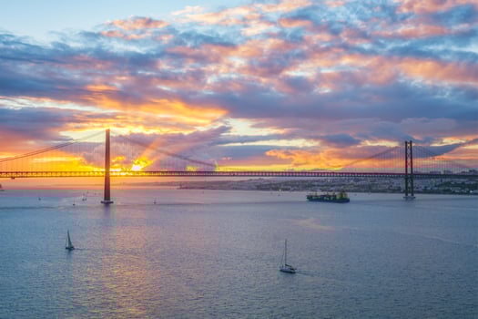 View of 25 de Abril Bridge over Tagus river on sunset. Lisbon, Portugal photo