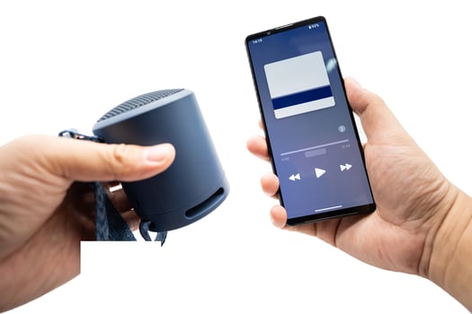Hand using phone connecting portable speaker. Using bluetooth speaker with smart phone. photo