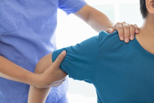 man was admitted for treatment of muscle pain in back of his shoulder due to working hard and causing muscle inflammation. doctor is treating man muscle pain in his back and shoulders due to overwork. photo