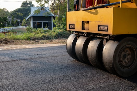 Heavy vibration yellow steamroller or soil compactor working on hot-mix asphalt pavement road photo