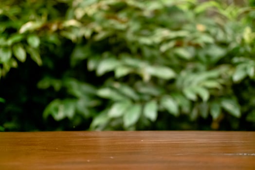 Selective Focus and Blur on Wooden Table with Green Leaves as Commercial Background photo