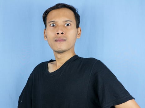 Angry young Asian man expression with pointing gesture and bulging eyes. Mental health concept photo