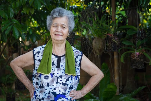 Senior woman wearing casual clothing, smiling, and exercise while standing in a garden. Concept of aged people and healthcare photo