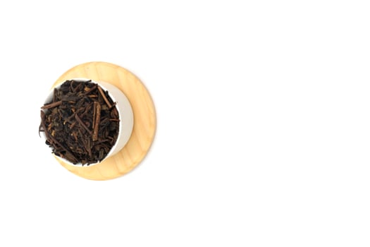 Dry black tea in round bowl isolated on white background photo