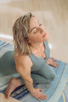 A 50-year-old woman does yoga at home photo