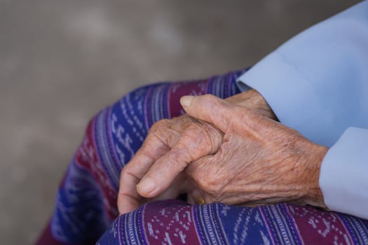 Close-up of hands elderly woman's joined together. Focus on hands wrinkled skin. Space for text. Concept of aged people and healthcare photo