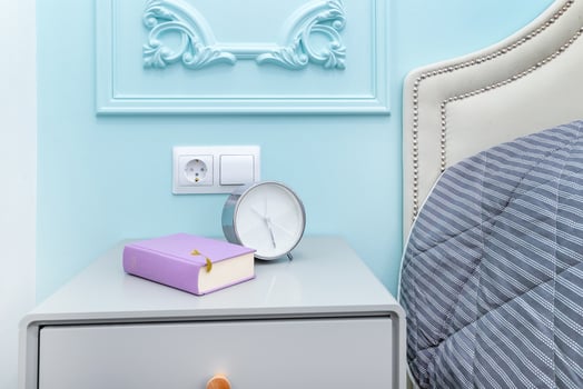 Alarm clock with a book on the bedside table photo