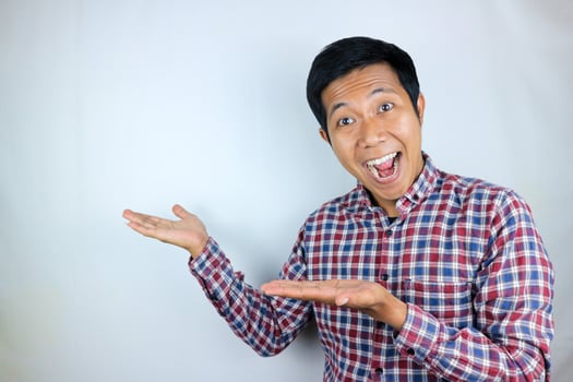 Asian man expression smiling while pointing to the side presenting the product. advertising concept photo