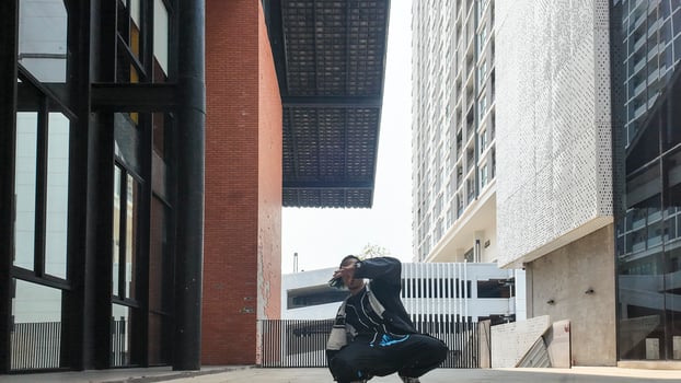 ASian man is dancing in hip hop style at outdoor space. Professional solo dancer is performing in public area. photo