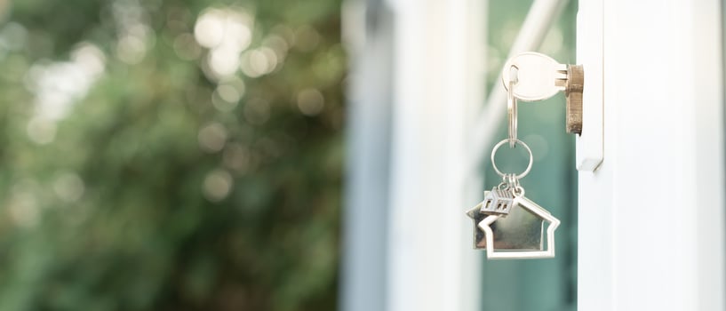 Landlord key for unlocking house is plugged into the door. Second hand house for rent and sale. keychain is blowing in the wind. mortgage for new home, buy, sell, renovate, investment, owner, estate photo