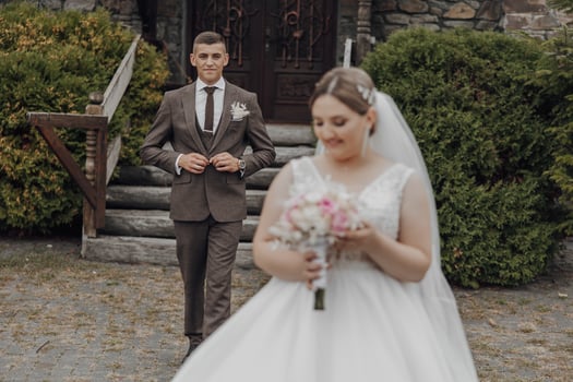 A bride and groom are standing in front of a church door photo