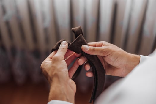 A man is holding a tie in his hands photo