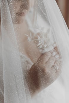 A woman is wearing a white veil with a flower in it photo