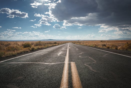 Arizona Desert Road with Dramatic Sky, Golden Grasslands, and Distant Mountains photo