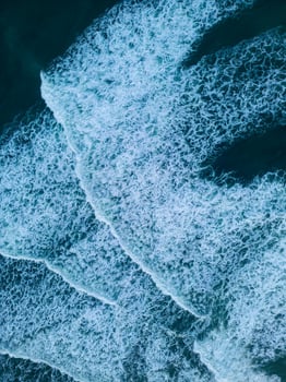 Iceland scenery black sand beach on atlantic ocean coastline, majestic northern country with natural freezing cold setting. Drone shot of icelandic nature with waves hitting the beachfront. photo