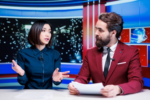 Diverse broadcasters reading daily headlines in newsroom, using media outlets papers to present latest information and updates about events. Journalists team reporting live for tv newscast. photo
