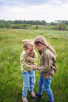 sisters hug and protect each other from the wind in the field photo