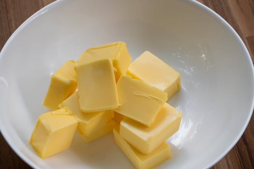 Butter slices are placed on a plate, Cut butter into cubes for baking cake photo