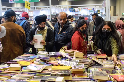 Delhi, India, February 17 2024 - Various age group people reading variety of Books on shelf inside a book-stall at Delhi International Book Fair, Books in Annual Book Fair at Bharat Mandapam complex photo
