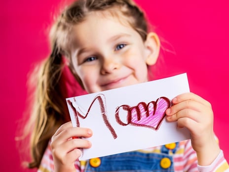 Little girl giving her hand writing greeting card to her mom. photo