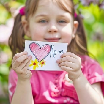 Little girl giving her hand writing greeting card to her mom. photo