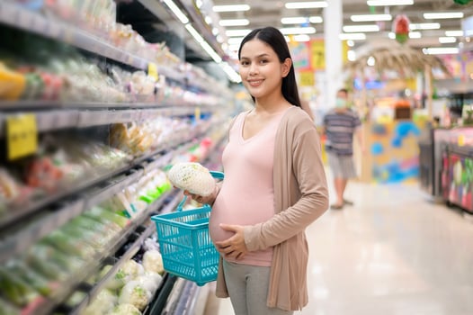 Beautiful pregnant woman shopping healthy food at grocery shop photo