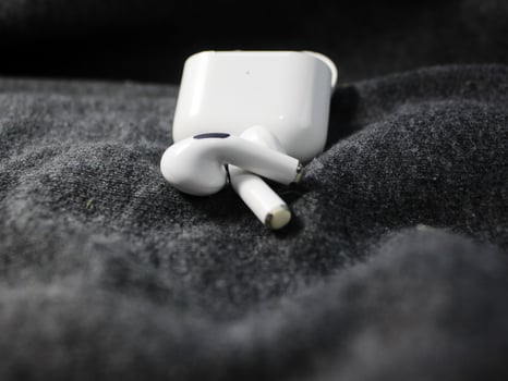 Closeup white TWS true wireless stereo earbuds in case isolated on black background. photo
