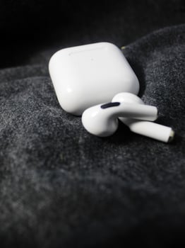 Closeup white TWS true wireless stereo earbuds in case isolated on black background. photo