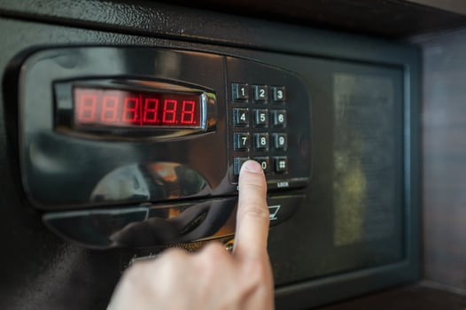 Finger are pressing the number keys of electric safe photo