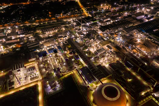 Industrial factory with chemical refinery and building material glowing light at night photo