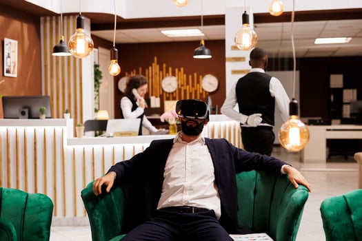 Businessman works with vr headset in hotel lobby, using new 3d interactive vision glasses before doing check in process. Young adult with virtual reality technology on business trip. photo