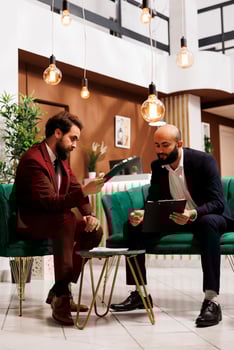 Team undertake fruitful exchange of ideas, leveraging their collective corporate expertise. Business travellers in suits checked the formal conference attire, attention to detail and professionalism. photo