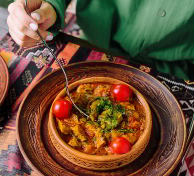 Traditional cuisine woman enjoying savory stew photo