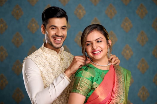 An Indian Couple In Traditional Outfit Presenting Necklace To His Wife photo