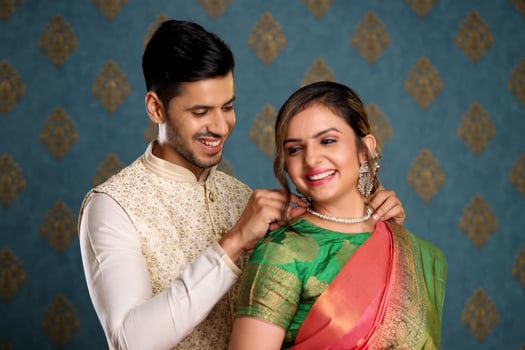 Image Of Nice Couple Dressed In Traditional Indian Attire Tying Or Presenting Necklace To His Wife photo