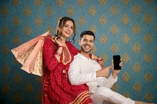Picture Of An Adorable Couple Wearing Traditional Indian Attire Holding A Plate Of Ladoos In Their Hands And Smile photo