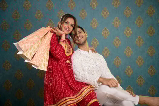 Stock Image Of A Husband And Wife Wearing Traditional Outfits Posing In Front Of The Camera Holding Shopping Bags During The Diwali Festival photo