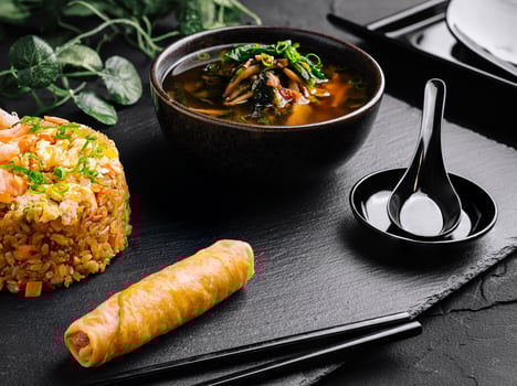 Asian cuisine delight fried rice, spring roll, and soup photo