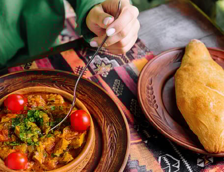 Traditional cuisine woman enjoying savory stew and bread photo