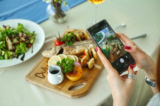 Woman Taking a Picture of Food on Her Phone photo