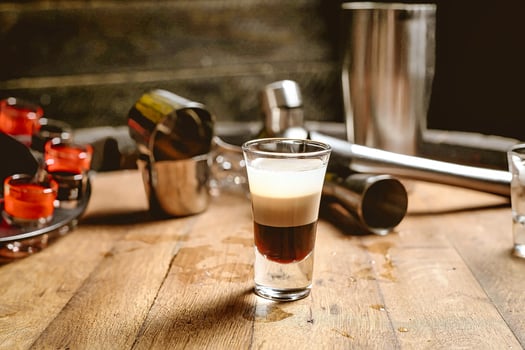 Wooden Table With Shot Glass Filled With Liquid photo