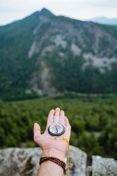 Orienteering on the terrain with a compass, a navigation device for extreme situations, a magnetic needle points north. photo