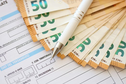 Filling italian tax form process with pen and euro money bills close up. Tax paying period photo