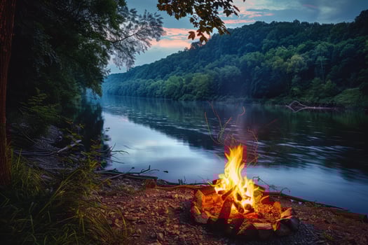 Peaceful riverside campsite illuminated by the flickering light of campfire photo